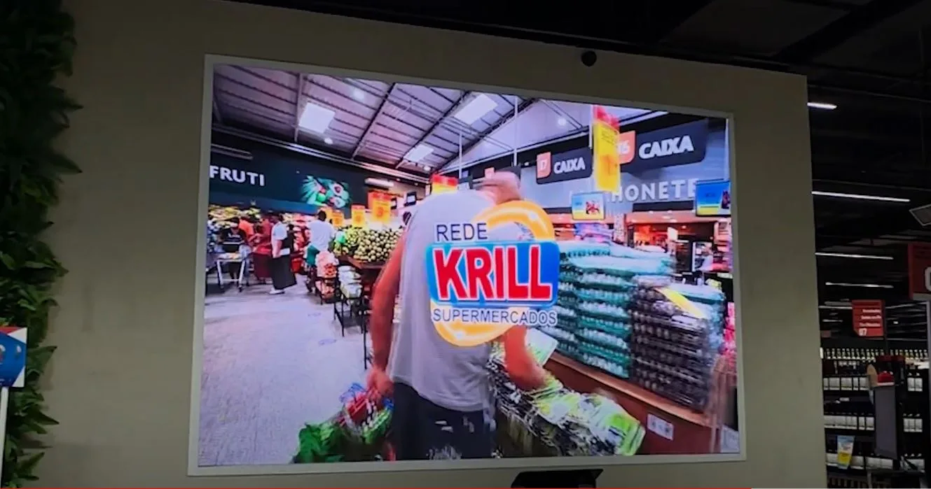 Telão de LED com ofertas de hortifruti acima dos caixas